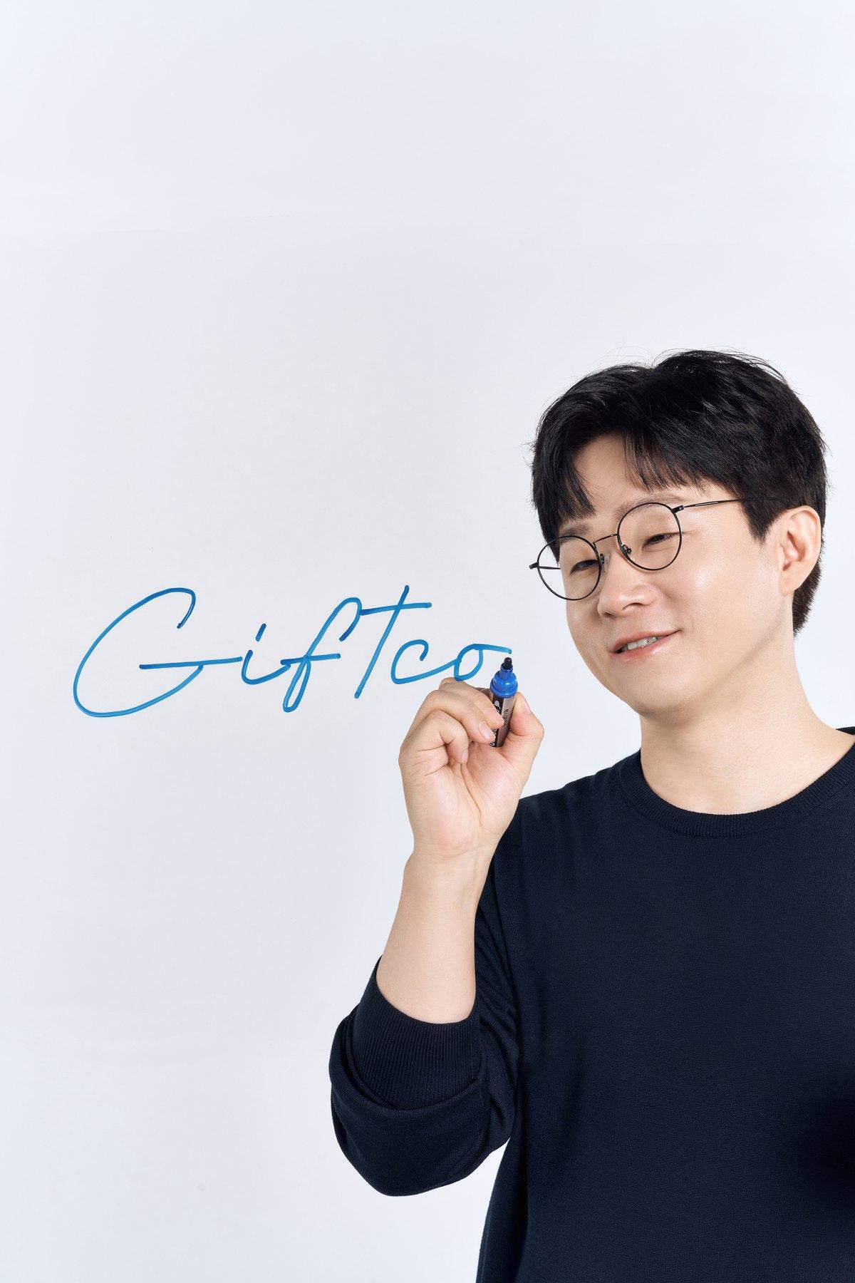 유리판에 Giftco를 쓰는 인물